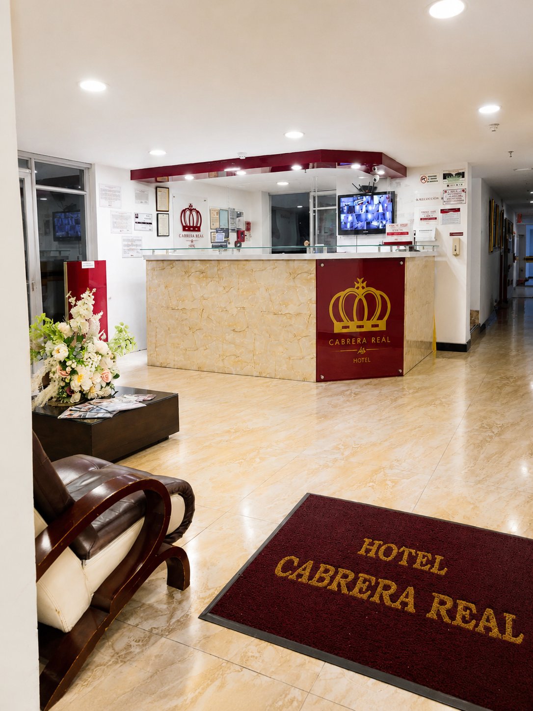 Recepción del Hotel Cabrera Real con el logo de la corona dorada